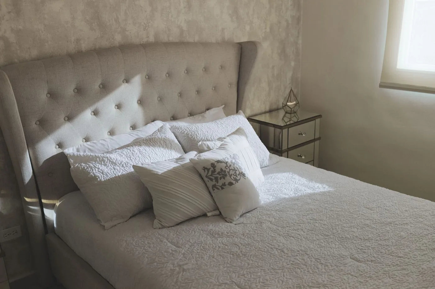 Pillows layered on a neatly made bed
