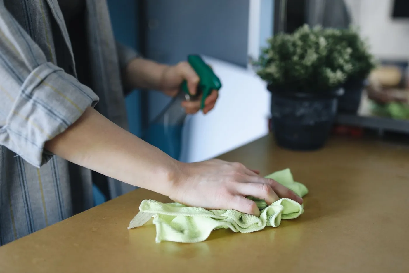 A table being wiped with a reusable cleaning cloth